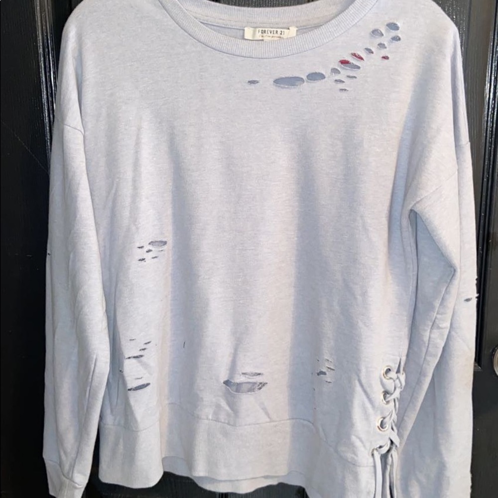 Gray pullover. Has holes and a tie on the left corner.